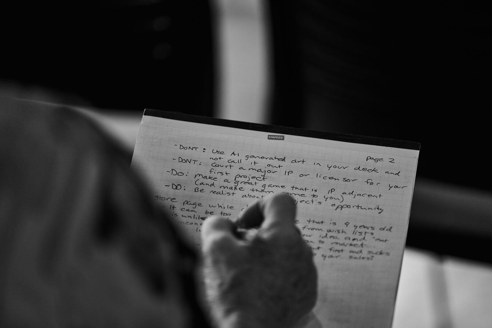 Over an attendee's shoulder at their notebook: a handwritten page of DO and DON'T notes from the talk.