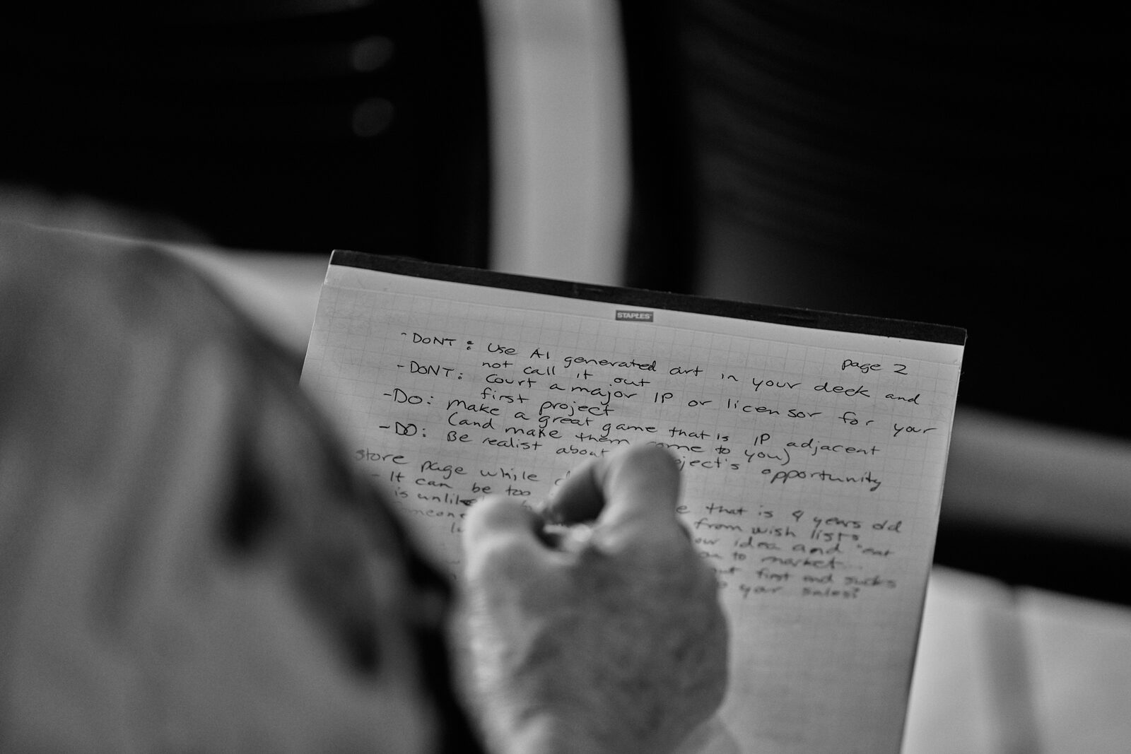 Over an attendee's shoulder at their notebook: a handwritten page of DO and DON'T notes from the talk.